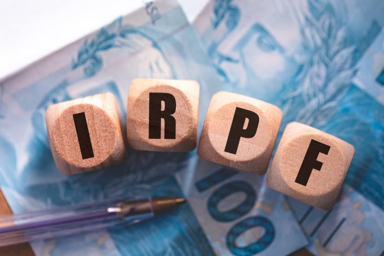 Notas de dinheiro com dados com as letras IRPF em cima